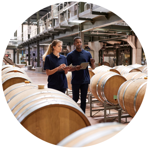 Circle with two employees walking among casks