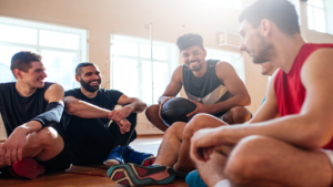 Men sitting in a circle with a basketball in one's hand
